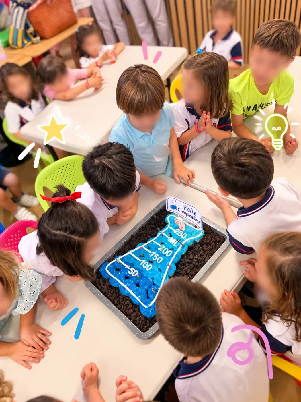 Niños alrededor de una tarta con forma de matraz