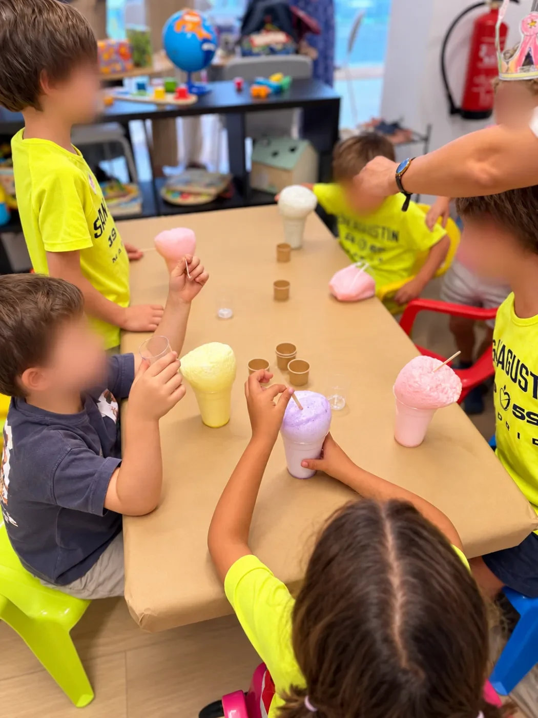 Niños con vasos de los que sale espuma de colores