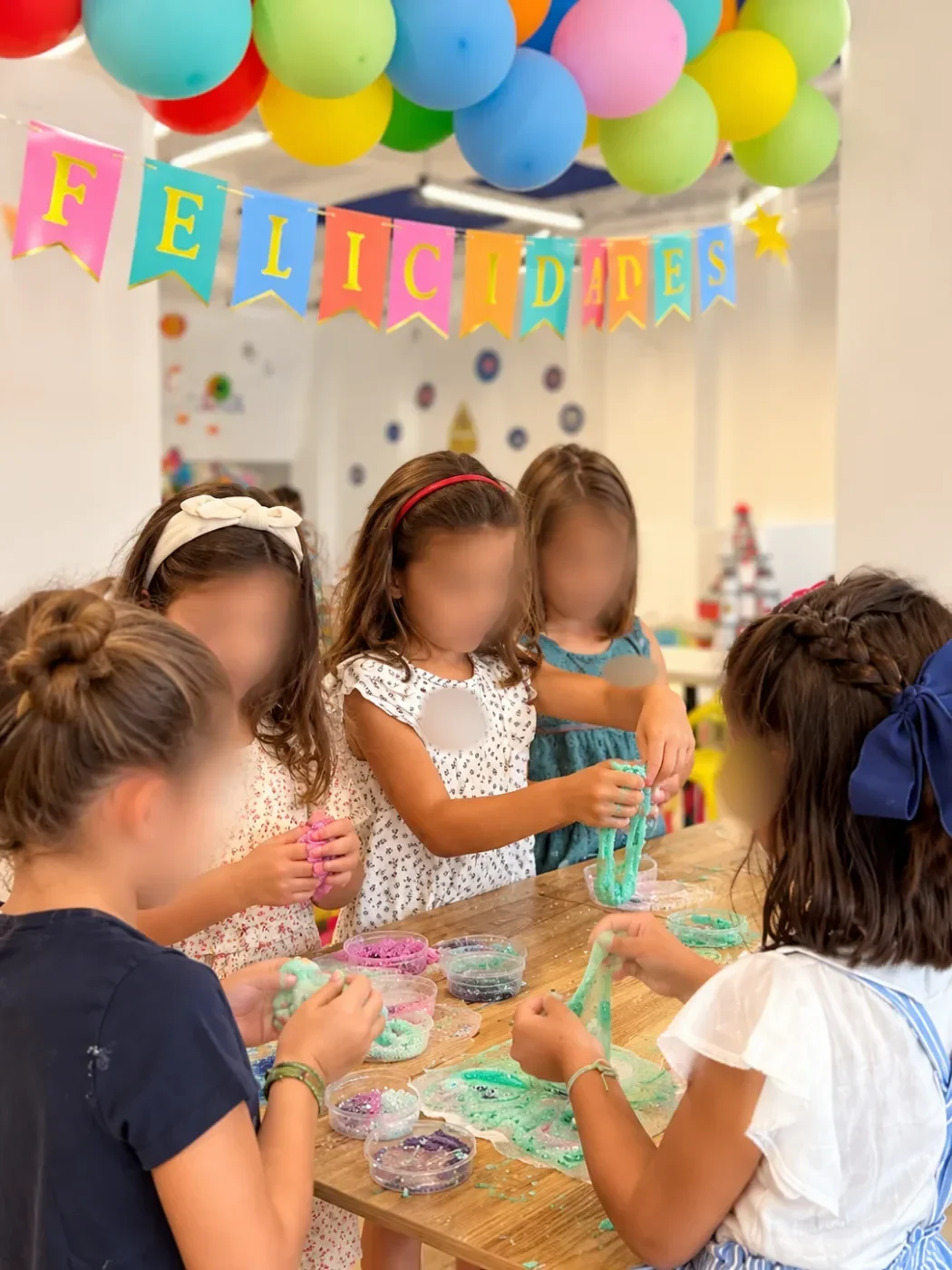 Niñas preparando slime de colores con purpurina