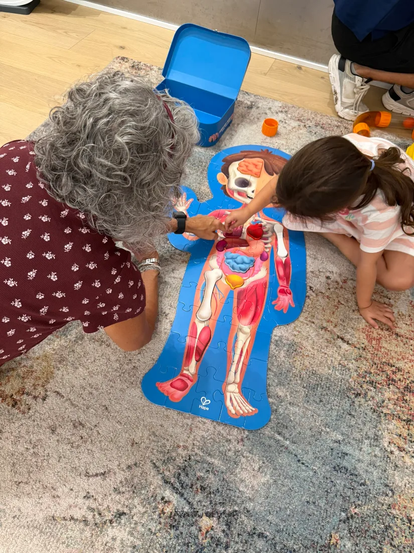 Una niña y una abuela montando un puzle del cuerpo humano en la zona STEAM